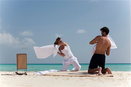 simsearch:6122-07699118,k - Couple having pillow fight on beach Photographie de stock - Premium Libres de Droits, Code: 6122-07699119