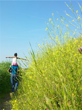 person walking field flowers - Daughter on father's shoulders in field Stock Photo - Premium Royalty-Free, Code: 6122-07699260