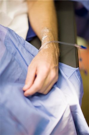 person in hospital bed overhead - Patient with intravenous drip in arm Stock Photo - Premium Royalty-Free, Code: 6122-07699209