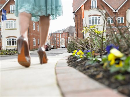 Woman walking on suburban street Stock Photo - Premium Royalty-Free, Code: 6122-07699232