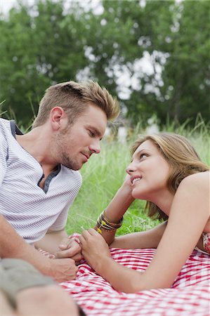 simsearch:649-03882395,k - Couple laying on picnic blanket Foto de stock - Royalty Free Premium, Número: 6122-07699399