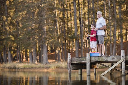Boy fishing with grandfather in lake Stock Photo - Premium Royalty-Free, Code: 6122-07699441