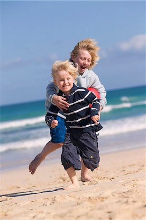 Boys playing with red ball on beach Stock Photo - Premium Royalty-Free, Code: 6122-07699499