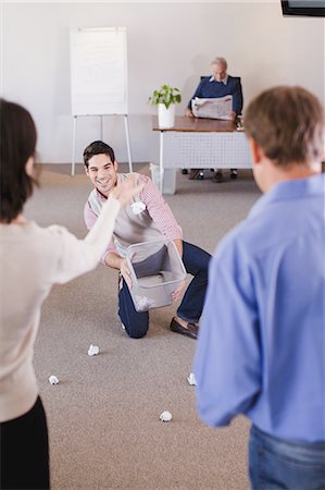 picture of woman kneeling down from behind - Businesswoman aiming trash into can Stock Photo - Premium Royalty-Free, Code: 6122-07699418