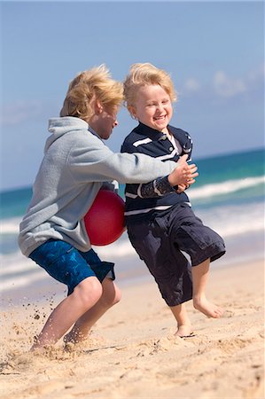 Boys playing with red ball on beach Photographie de stock - Premium Libres de Droits, Code: 6122-07699500
