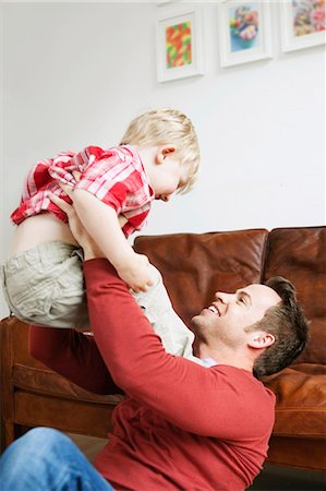 simsearch:6122-07706907,k - Father playing with son in living room Foto de stock - Sin royalties Premium, Código: 6122-07699525