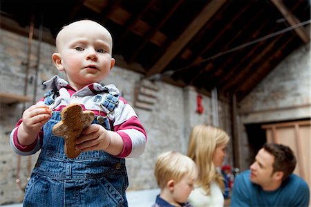 Toddler boy holding cookie in kitchen Stock Photo - Premium Royalty-Free, Code: 6122-07699528