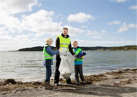 people picking up rubbish on the beach - Father and sons cleaning beach Stock Photo - Premium Royalty-Free, Code: 6122-07699887