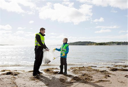 Father and son cleaning beach Stock Photo - Premium Royalty-Free, Code: 6122-07699891
