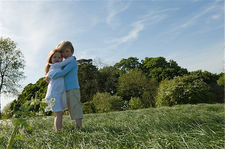 simsearch:649-05950472,k - Children hugging in field Fotografie stock - Premium Royalty-Free, Codice: 6122-07699825