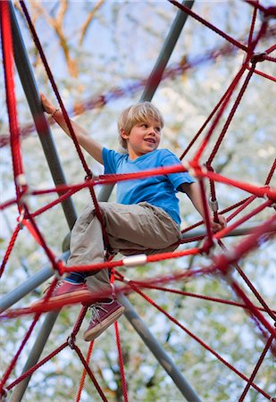 Boy climbing at playground Photographie de stock - Premium Libres de Droits, Code: 6122-07699837