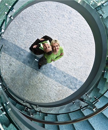 spiral staircase people - Businesswomen standing in stairwell Stock Photo - Premium Royalty-Free, Code: 6122-07700042