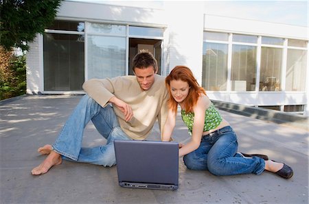 simsearch:6122-07698450,k - Couple using laptop together outdoors Photographie de stock - Premium Libres de Droits, Code: 6122-07700076