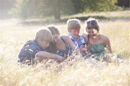 Children using cell phones in field Stock Photo - Premium Royalty-Free, Code: 6122-07700195