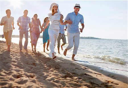 Newlywed couple on beach with friends Stock Photo - Premium Royalty-Free, Code: 6122-07700580