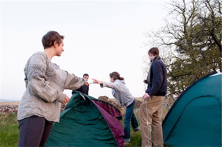simsearch:6122-07693891,k - People pitching tents at campsite Stock Photo - Premium Royalty-Free, Code: 6122-07700608