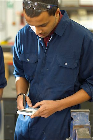 Worker using calculator in factory Photographie de stock - Premium Libres de Droits, Code: 6122-07700637