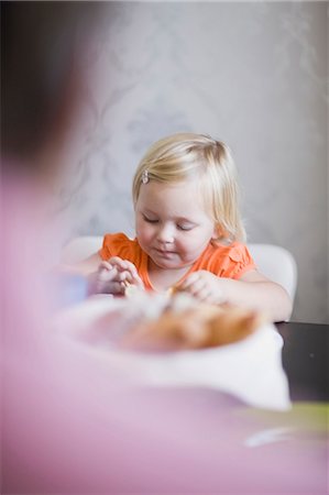 simsearch:6108-06167425,k - Toddler girl eating at dinner table Stock Photo - Premium Royalty-Free, Code: 6122-07700734