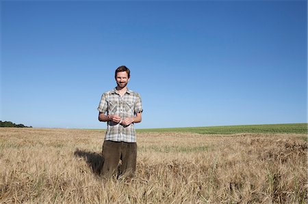 simsearch:6119-07451732,k - Man standing in wheat field Fotografie stock - Premium Royalty-Free, Codice: 6122-07700802