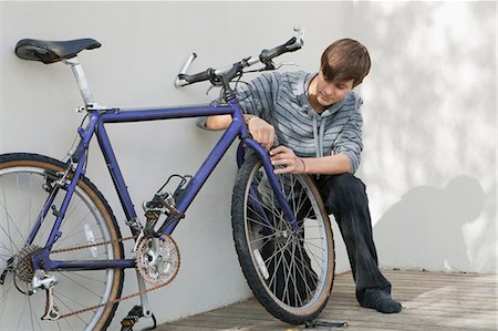 Teenage boy repairing bicycle Stock Photo - Premium Royalty-Free, Code: 6122-07700826