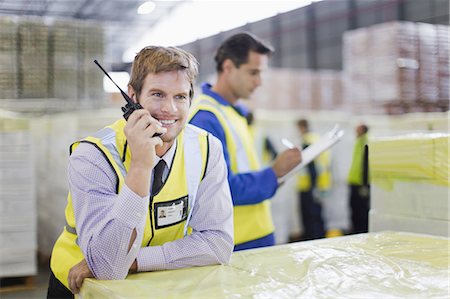 simsearch:6122-08229062,k - Worker using walkie talkie in warehouse Stock Photo - Premium Royalty-Free, Code: 6122-07700916