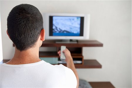 Man watching television in living room Photographie de stock - Premium Libres de Droits, Code: 6122-07701113