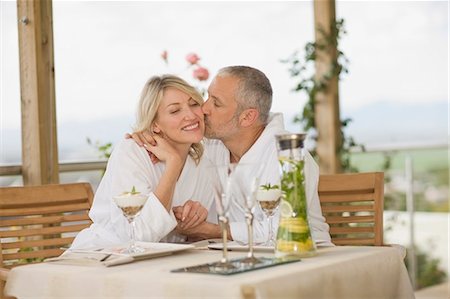 simsearch:649-02666212,k - Couple in bathrobes kissing at breakfast Photographie de stock - Premium Libres de Droits, Code: 6122-07701431