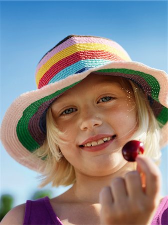Girl in sunhat holding cherry Stockbilder - Premium RF Lizenzfrei, Bildnummer: 6122-07701580