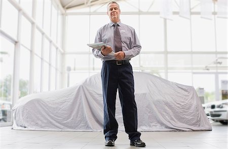 simsearch:649-05521296,k - Car salesman standing in showroom Stock Photo - Premium Royalty-Free, Code: 6122-07701517