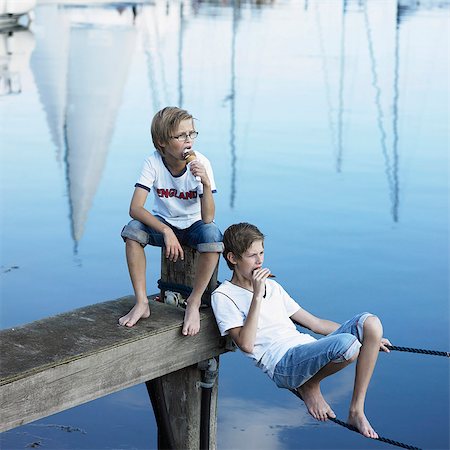 Boys eating ice cream on pier Stock Photo - Premium Royalty-Free, Code: 6122-07701779