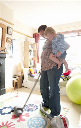 person watching side - Mother holding toddler while vacuuming Stock Photo - Premium Royalty-Free, Code: 6122-07701806