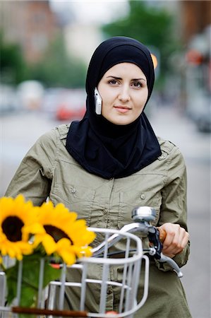 ropa tradicional - Woman in headscarf biking on cell phone Foto de stock - Sin royalties Premium, Código: 6122-07701943