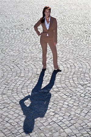 Businesswoman standing on cobbled road Photographie de stock - Premium Libres de Droits, Code: 6122-07702055