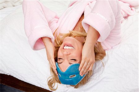 Woman on bed with eye mask on forehead Stock Photo - Premium Royalty-Free, Code: 6122-07702143