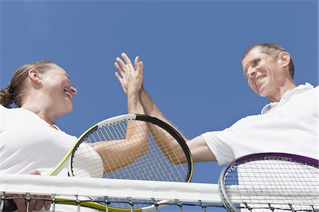 Older couple high fiving during tennis Fotografie stock - Premium Royalty-Free, Codice: 6122-07702114