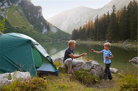 family, isolated, full length - Father and son eating at campsite Stock Photo - Premium Royalty-Free, Code: 6122-07702259