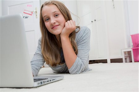 simsearch:6122-07703518,k - Smiling girl using laptop on floor Photographie de stock - Premium Libres de Droits, Code: 6122-07702347