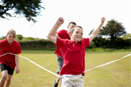 runner winning race - Boy cheering and crossing finish line Stock Photo - Premium Royalty-Free, Code: 6122-07702320