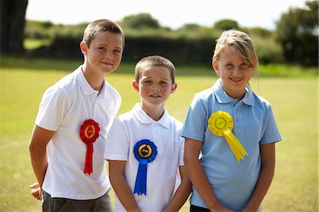 récompense - Children wearing ribbons in field Photographie de stock - Premium Libres de Droits, Code: 6122-07702326