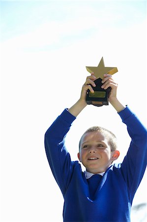 Student cheering with trophy Stock Photo - Premium Royalty-Free, Code: 6122-07702331