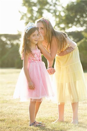 shocked tween girls - Sisters whispering outdoors Stock Photo - Premium Royalty-Free, Code: 6122-07702593