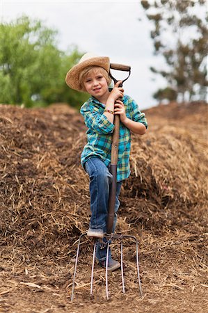 Boy using pitchfork in haystack Foto de stock - Sin royalties Premium, Código: 6122-07702647