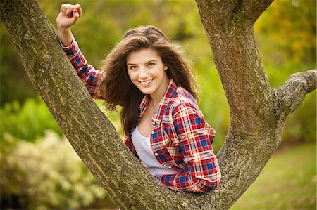 Teenage girl climbing tree in park Foto de stock - Sin royalties Premium, Código: 6122-07702740