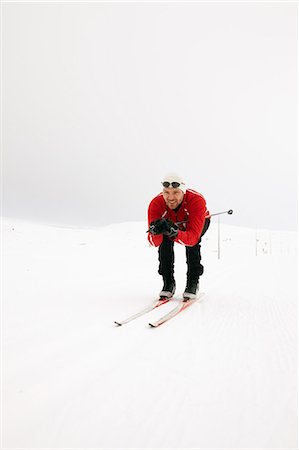 simsearch:6122-07706662,k - Man crouching while cross-country skiing Stock Photo - Premium Royalty-Free, Code: 6122-07702873