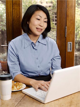 Businesswoman eating and working Stock Photo - Premium Royalty-Free, Code: 6122-07702976