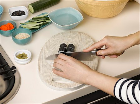 simsearch:649-06489663,k - Woman chopping sushi at table Photographie de stock - Premium Libres de Droits, Code: 6122-07702985