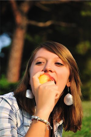 simsearch:6122-07703483,k - Teenage girl eating fruit in backyard Fotografie stock - Premium Royalty-Free, Codice: 6122-07703032