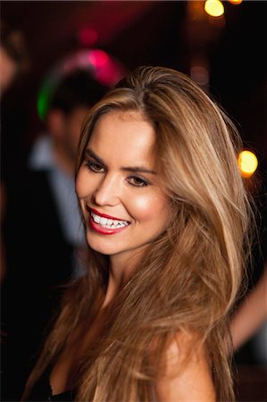 Smiling woman standing in club Foto de stock - Sin royalties Premium, Código: 6122-07703126