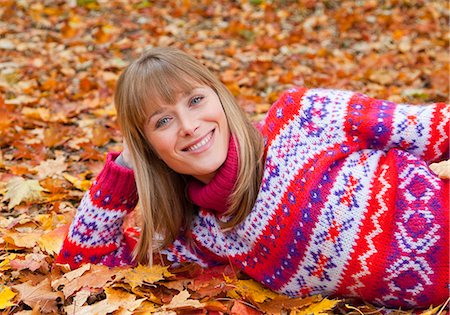 simsearch:649-06532692,k - Smiling woman laying in fall leaves Stockbilder - Premium RF Lizenzfrei, Bildnummer: 6122-07703259