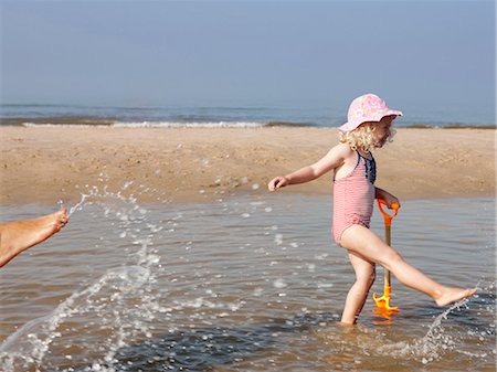 simsearch:6122-08229458,k - Child playing in water at beach Foto de stock - Royalty Free Premium, Número: 6122-07703283